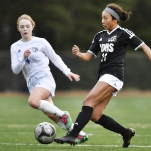 Juneau-Douglas’ Malia Miller, right, moves the ball against a defender in a high school soccer match