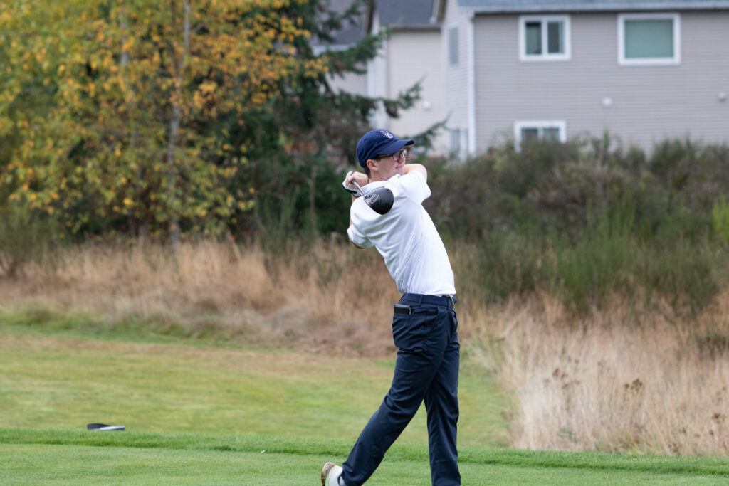 Men's golfer at the end of a full swing, with a complete twist in the upper body and club reaching almost all the way around.