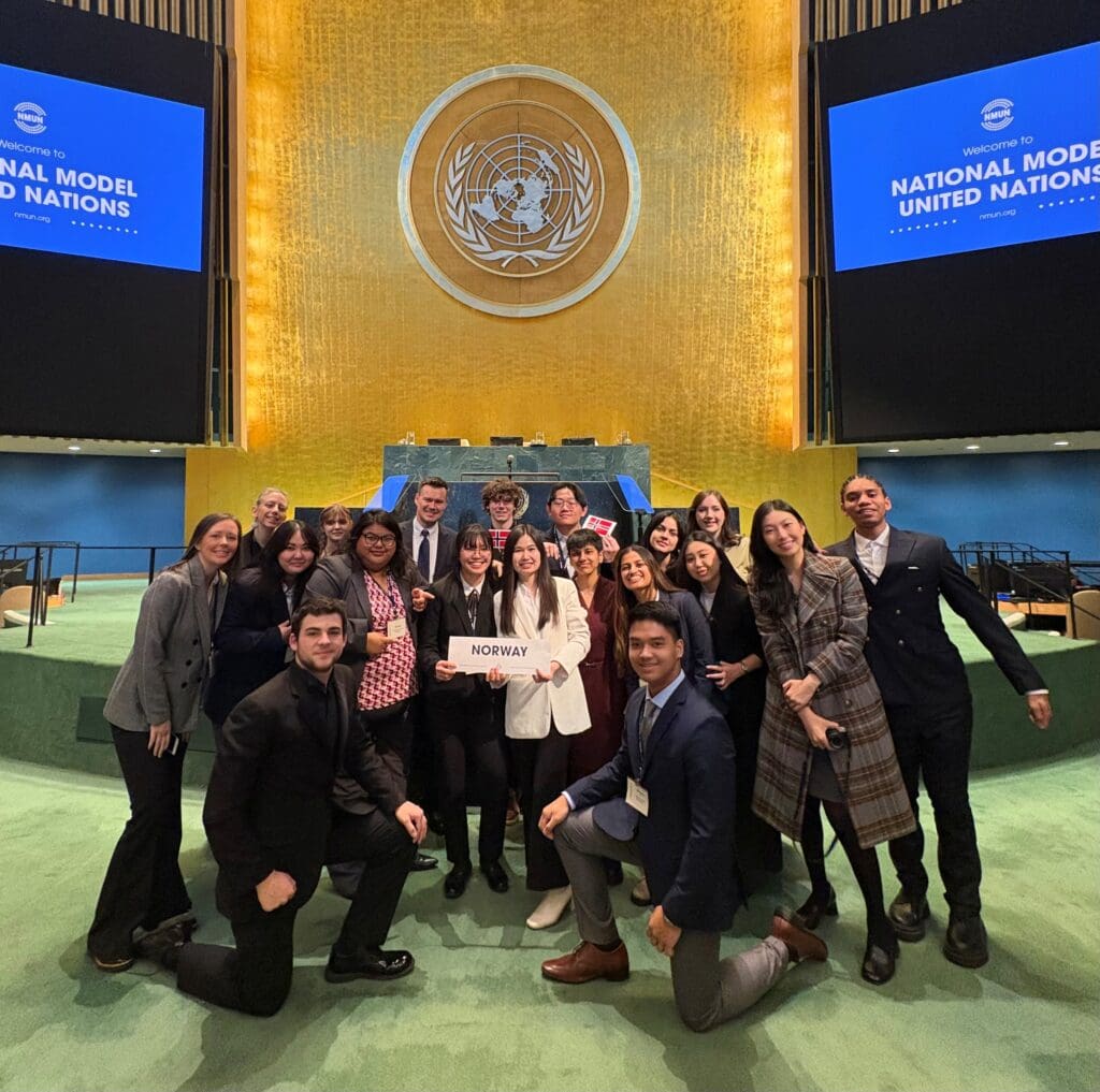 Group photo of BC students and faculty on the Model UN stage in New York representing Norway country