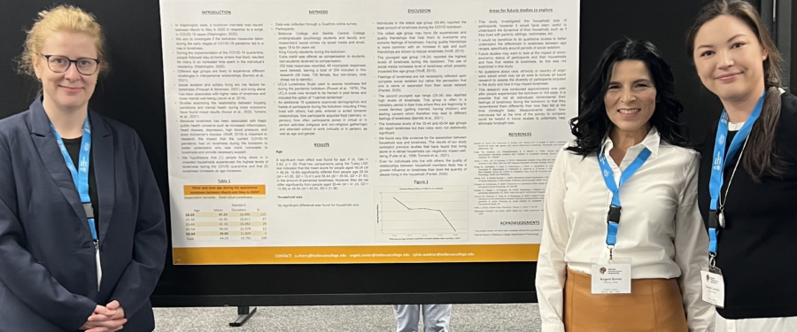 Two students with Dr. Lonson standing next to poster at WPA 2022