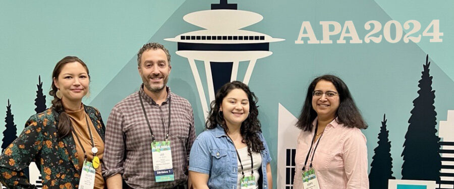 4 Bellevue College Psychology Faculty standing in front of the photo booth of APA, American Psychological Association 2024