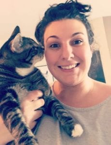 Access Specialist Jessica holding her grey and black striped cat, Marvin. He also has white feet.