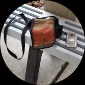 Purse and Cellphone on a Grey Bench
