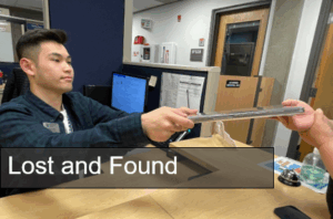 Student handing a student a laptop