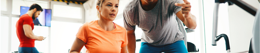 Two men and one women using equipment in the fitness center.