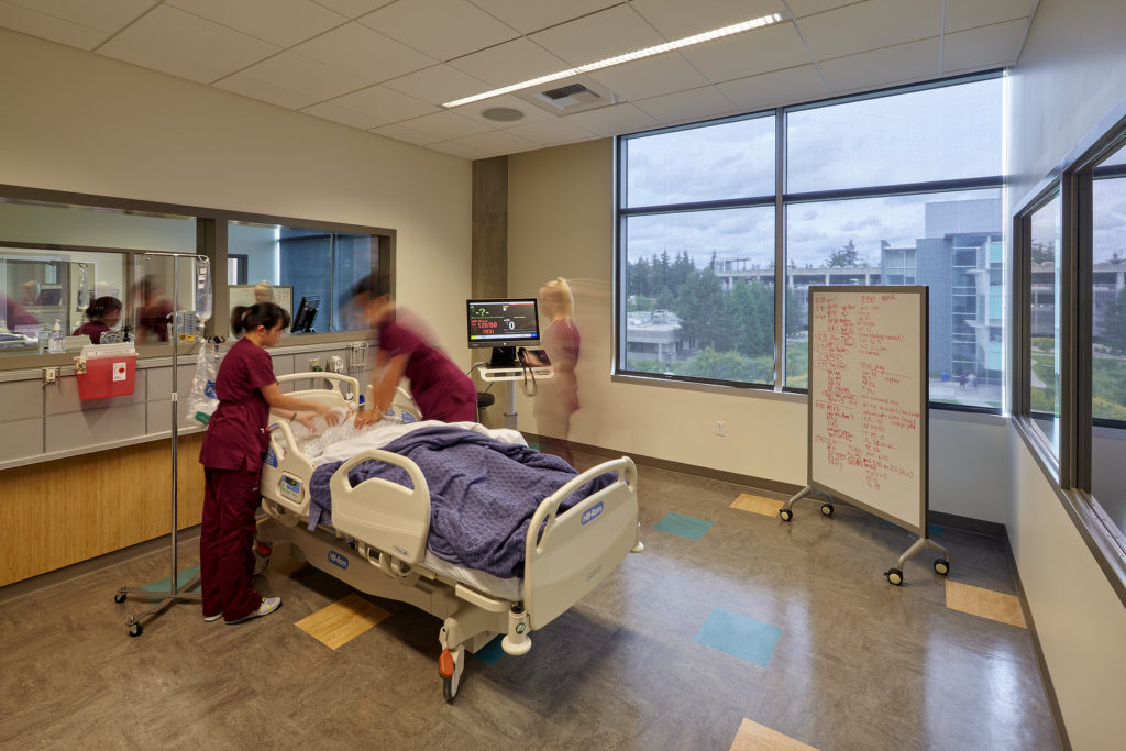 students practicing on a manikin in a gurney