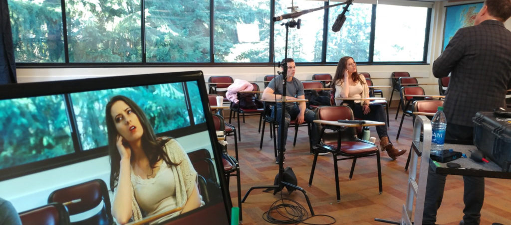 BC Film Studies class. students sitting behind boom microphones in a classroom.