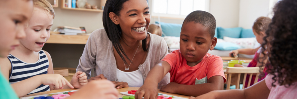 teacher smiling while children play