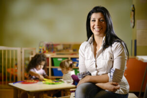 Picture of happy teacher with children eating in kindergarten