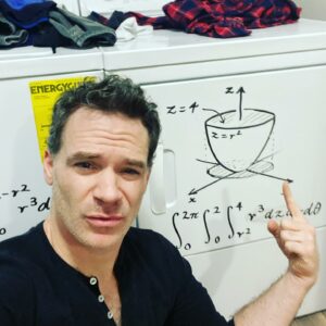 Math instructor Luke Rawlings uses his washer and dryer as a whiteboard to write out equations for students.