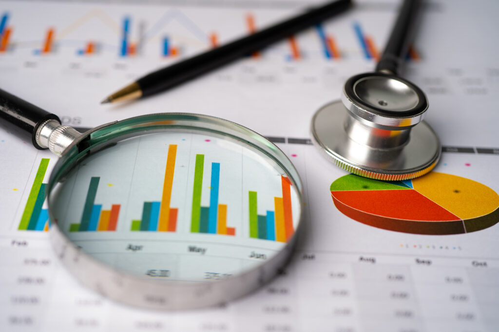 A stethoscope rests on a report with a bar chart