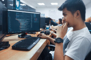 A student works on code in a computer lab.