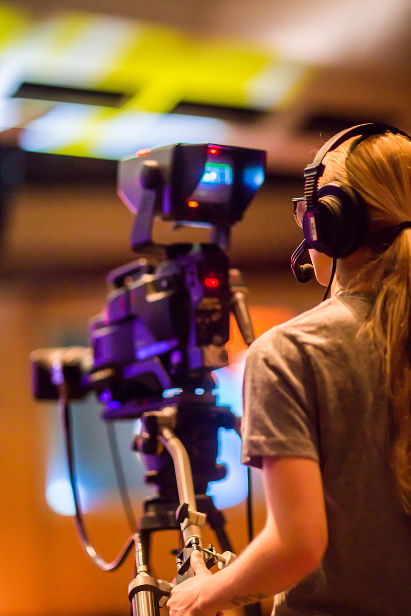 A video production student works behind the camera.