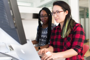 Two people look at a laptop together.