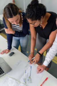 A student presents a diagram to a professor for feedback.