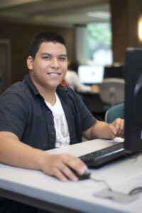 A smiling student works in the Bellevue College computer lab.