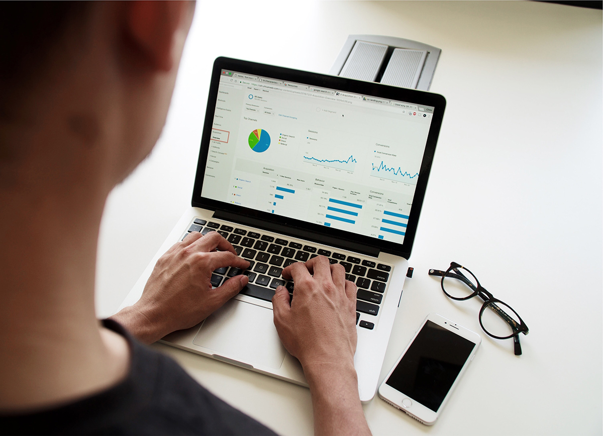 A person works on laptop charts and graphs.