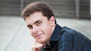 Young man with short brown hair and slight smile