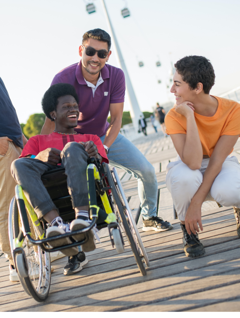 three students, one in a wheelchair, one wearing dark glasses, and one crouching down