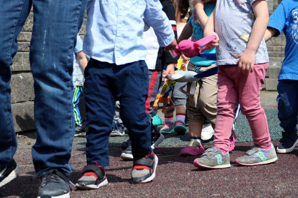 Children walking holding on to a rope
