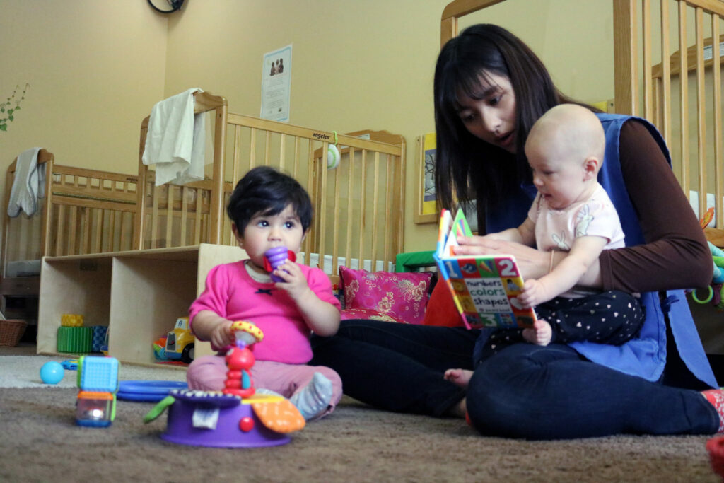 Teacher reading with two babies