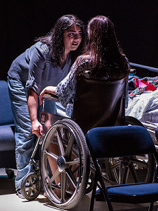 one woman talking to another woman sitting in a wheelchair