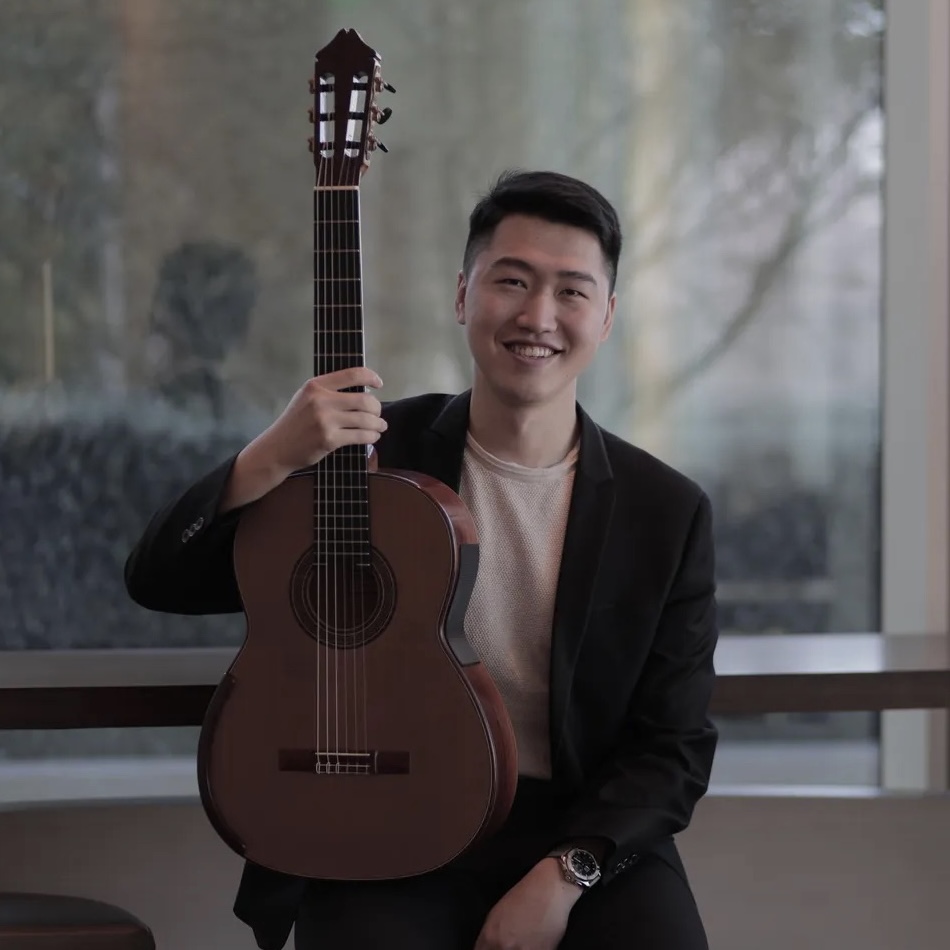 TY Zhang holding his guitar