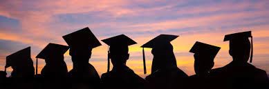 graduates silhouetted against sunset