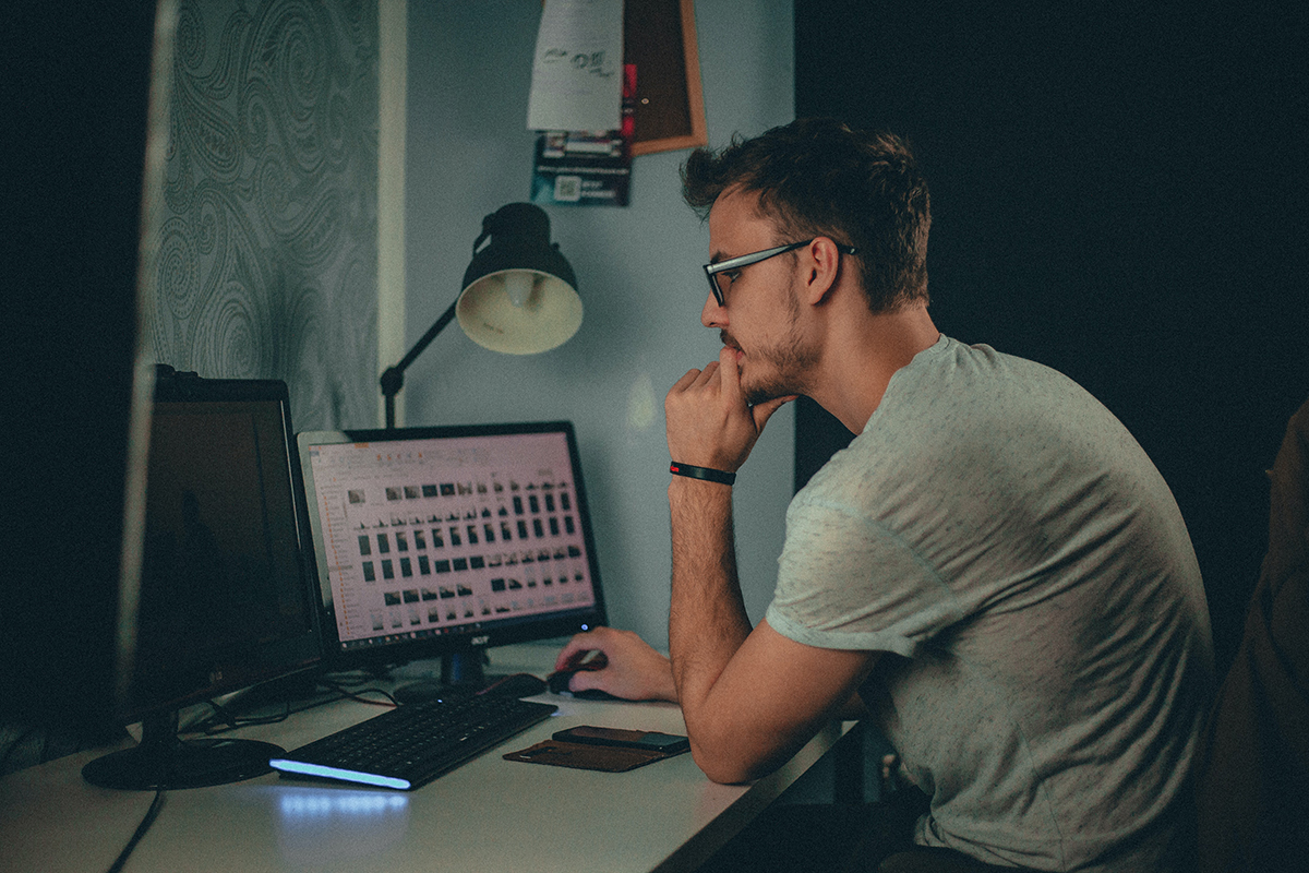 A student works on graphic images on two desktop computers.