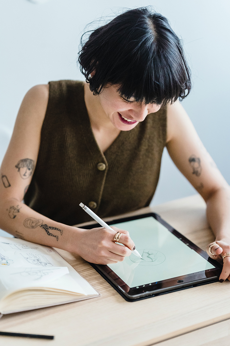 A student draws a design on a tablet.