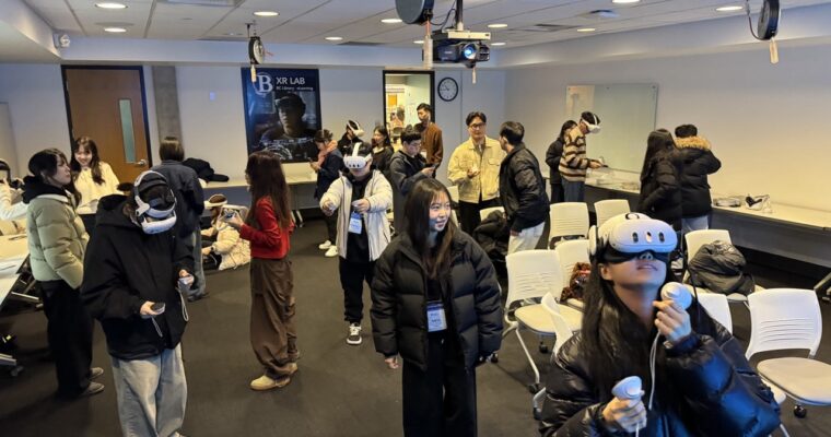A group of students from South Korea experience XR in a classroom setting and many of them are wearing VR headsets and holding controllers.
