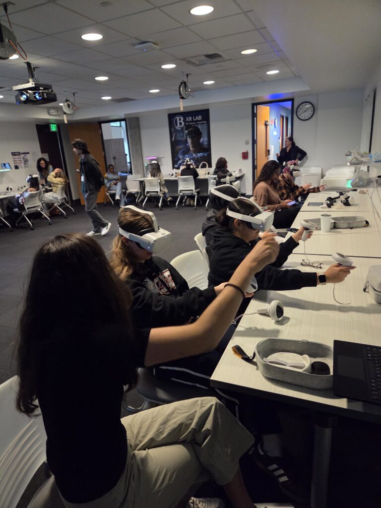 Maria Sanchez, the XR Faculty Lead assists student visitors with their headset experiences.